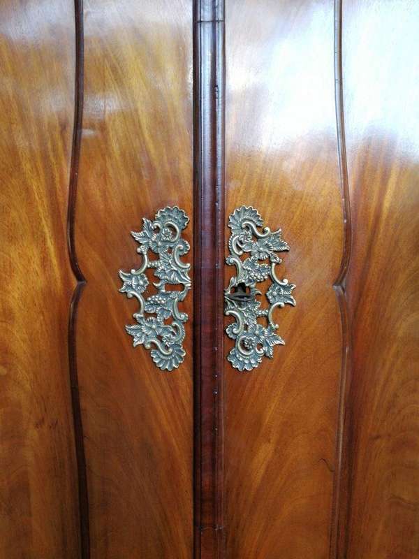 An 18th century (circa 1770) Dutch mahogany cabinet on bombe base/armoire with the original brass...