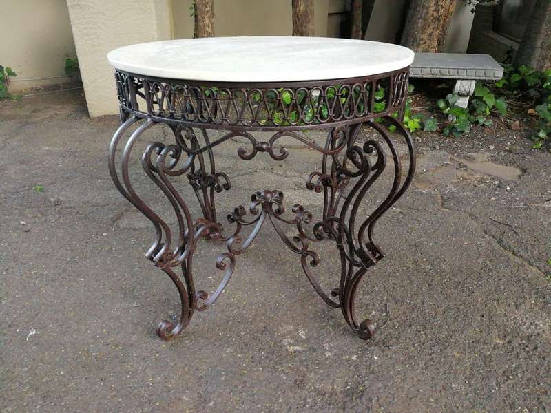 An imported wrought iron table with marble top