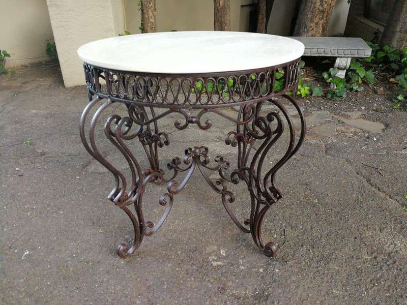 An imported wrought iron table with marble top