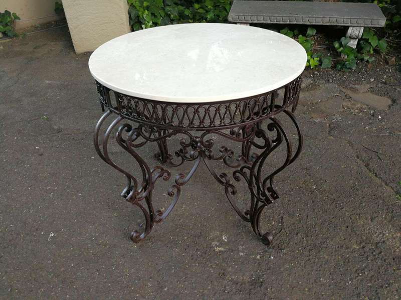 An imported wrought iron table with marble top