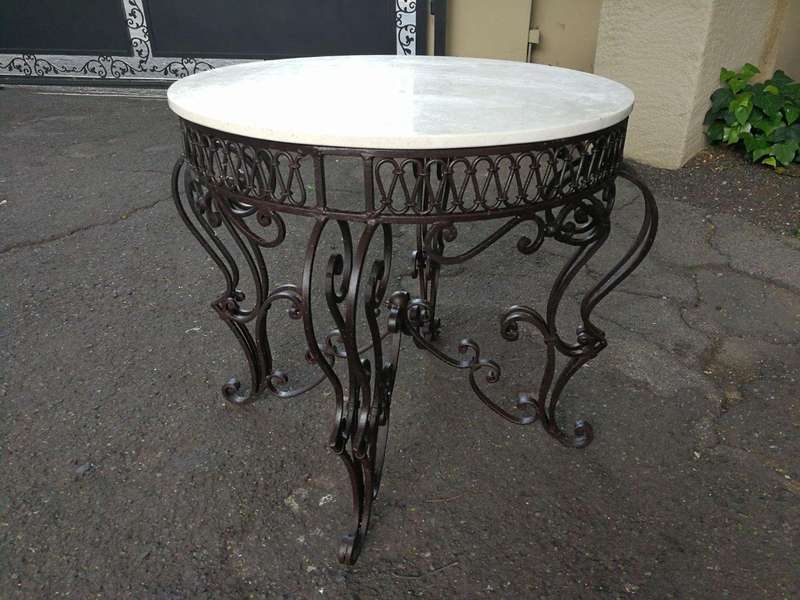 An imported wrought iron table with marble top