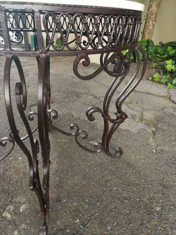 An imported wrought iron table with marble top