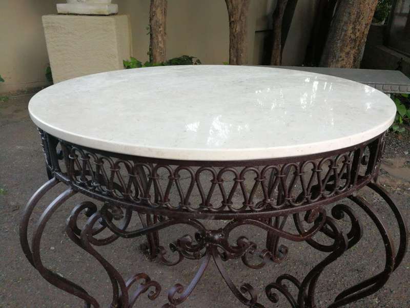 An imported wrought iron table with marble top