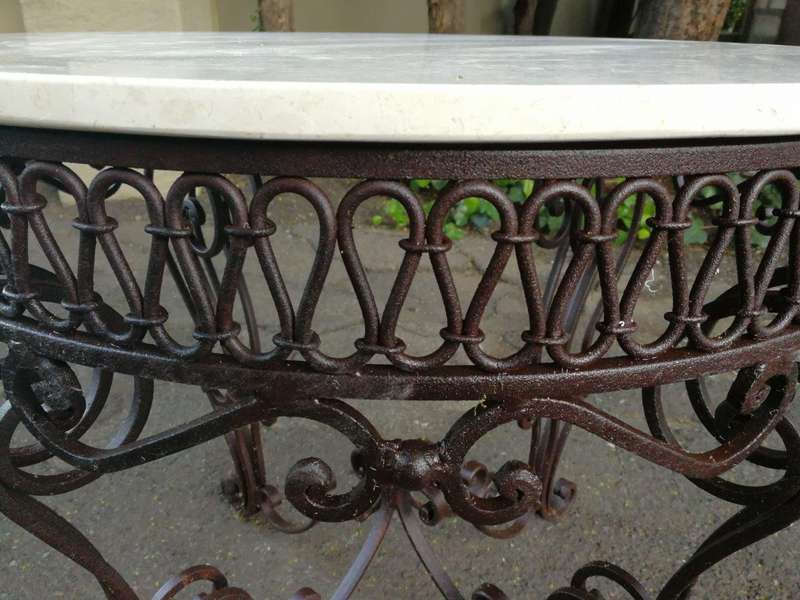 An imported wrought iron table with marble top