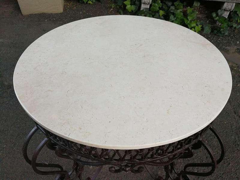 An imported wrought iron table with marble top