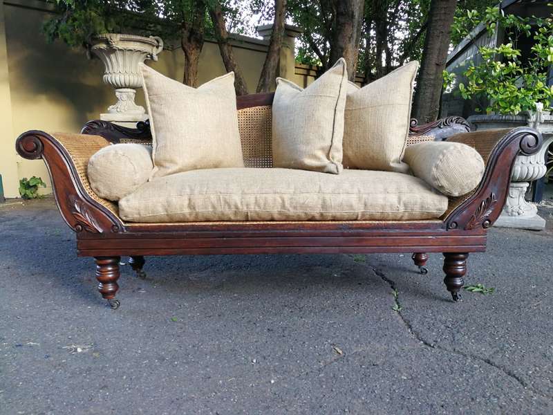 An Antique Victorian Carved Mahogany and Rattan Settee On Castors with Hessian Cushions and Bolsters