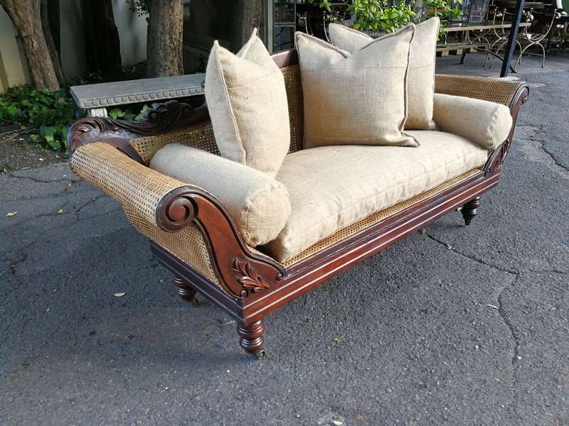 An Antique Victorian Carved Mahogany and Rattan Settee On Castors with Hessian Cushions and Bolsters
