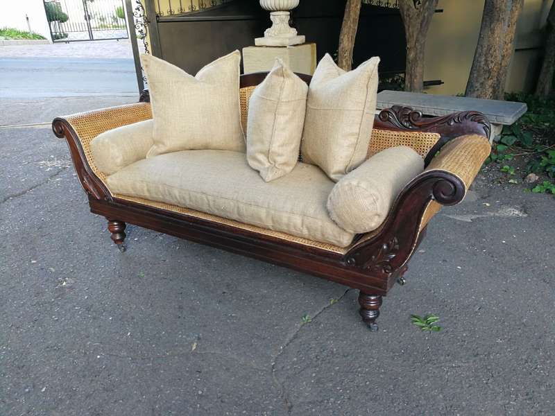 An Antique Victorian Carved Mahogany and Rattan Settee On Castors with Hessian Cushions and Bolsters