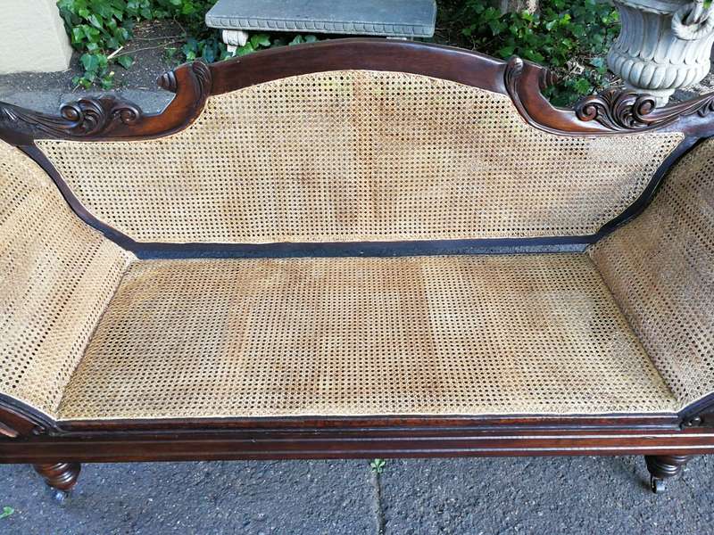 An Antique Victorian Carved Mahogany and Rattan Settee On Castors with Hessian Cushions and Bolsters