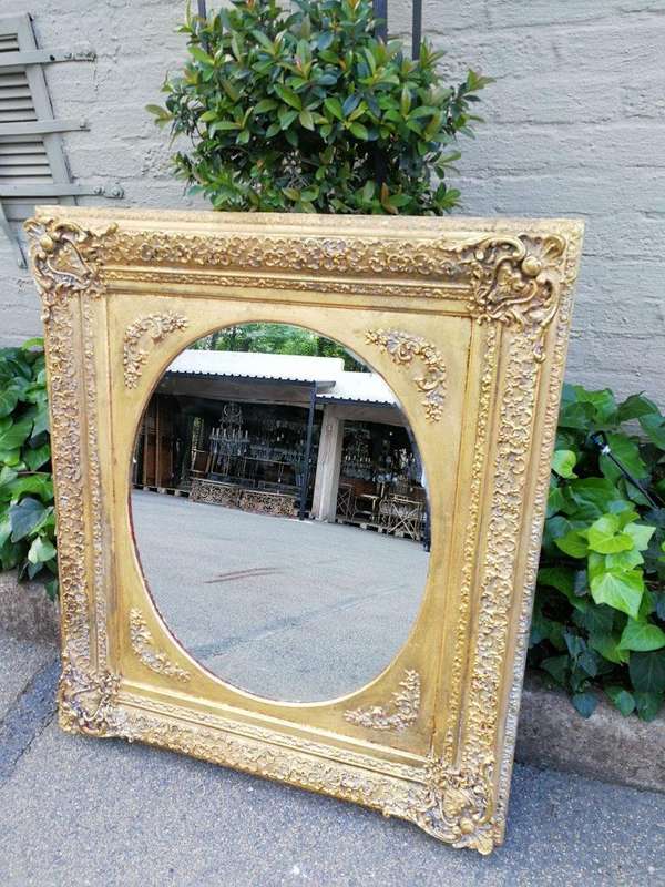 An Early 20th Century Gilded Oval Mirror Within A Rectangular Frame