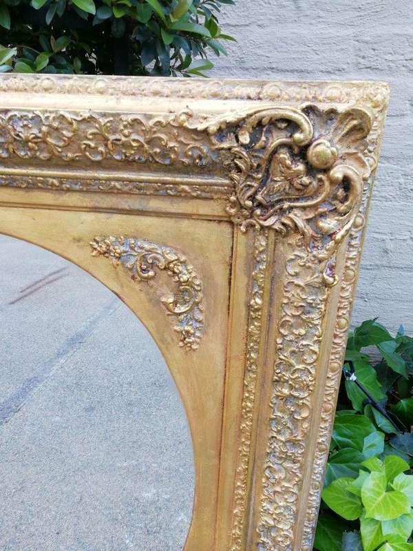 An Early 20th Century Gilded Oval Mirror Within A Rectangular Frame