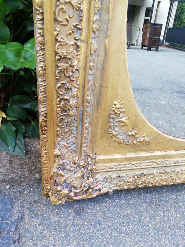 An Early 20th Century Gilded Oval Mirror Within A Rectangular Frame
