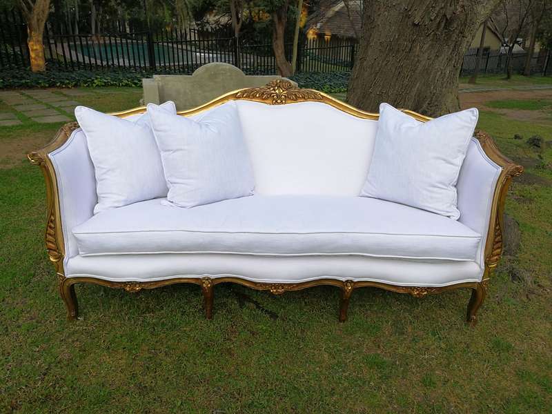 A French Louis XVl Style Gilded Settee Upholstered in a White Linen with Three Scatter Cushions