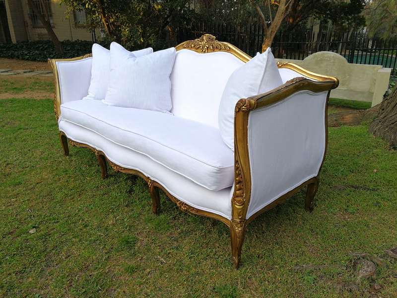 A French Louis XVl Style Gilded Settee Upholstered in a White Linen with Three Scatter Cushions