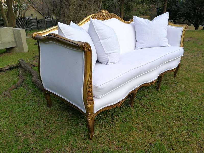A French Louis XVl Style Gilded Settee Upholstered in a White Linen with Three Scatter Cushions