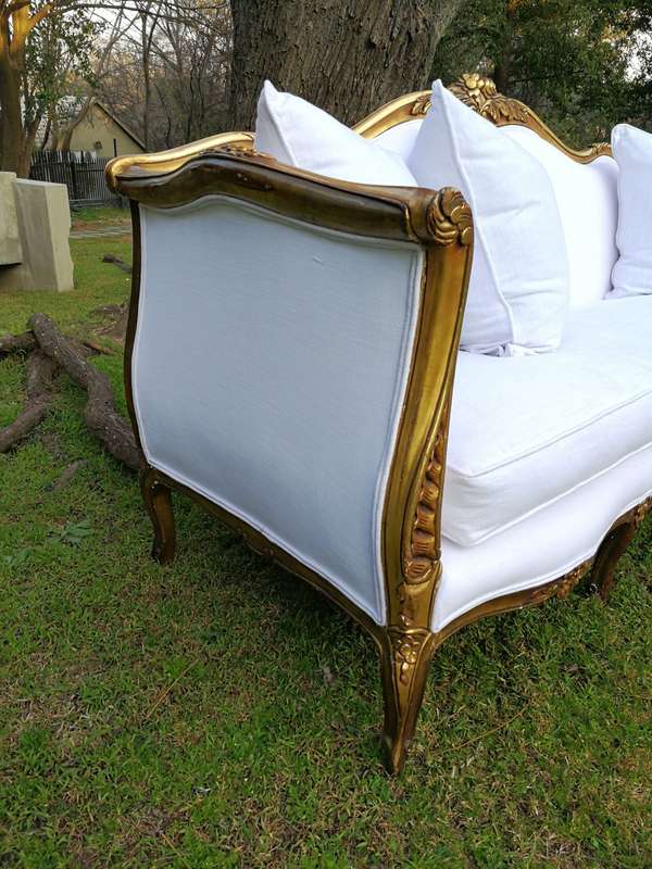 A French Louis XVl Style Gilded Settee Upholstered in a White Linen with Three Scatter Cushions