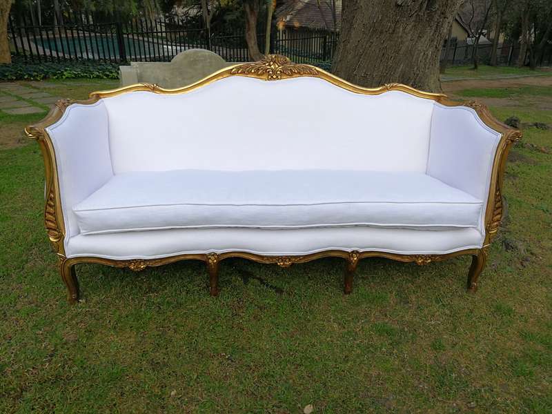 A French Louis XVl Style Gilded Settee Upholstered in a White Linen with Three Scatter Cushions
