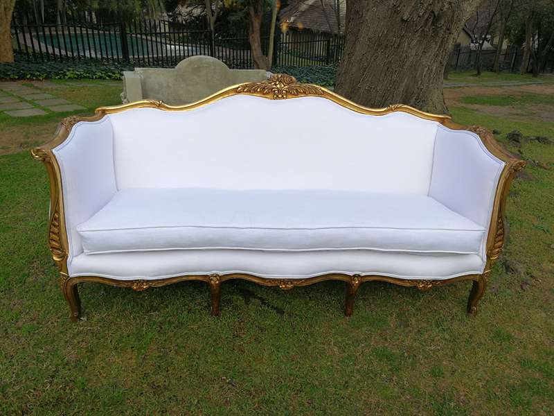 A French Louis XVl Style Gilded Settee Upholstered in a White Linen with Three Scatter Cushions