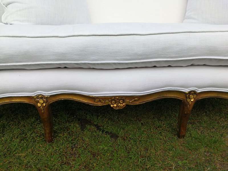 A French Louis XVl Style Gilded Settee Upholstered in a White Linen with Three Scatter Cushions