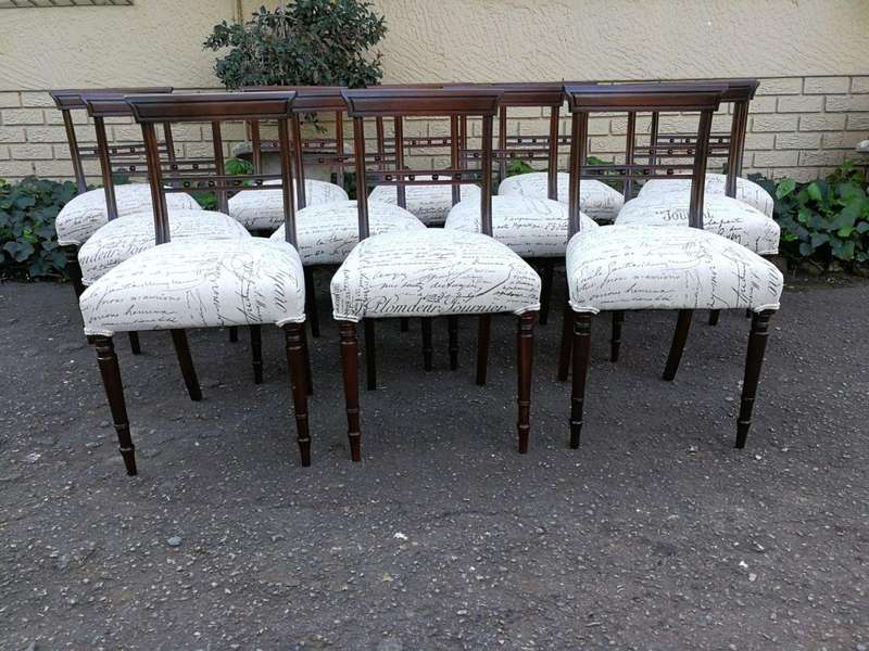 A Set of Twelve Regency Mahogany Dining Chairs upholstered in an exclusive and custom-made hand p...
