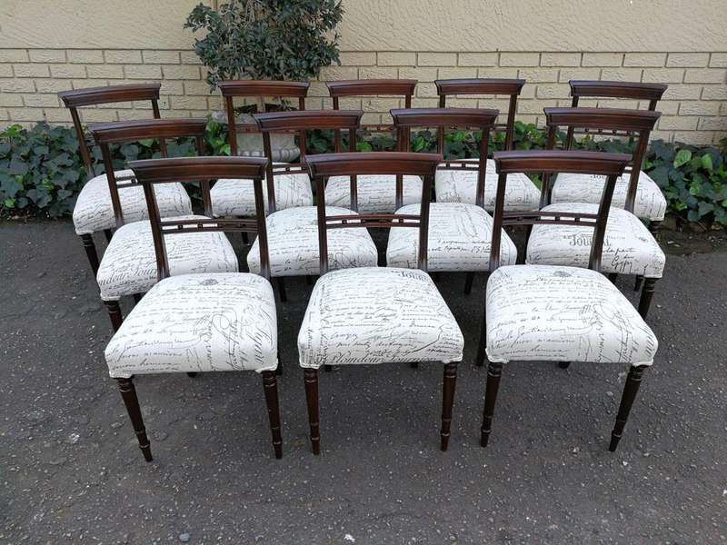 A Set of Twelve Regency Mahogany Dining Chairs upholstered in an exclusive and custom-made hand p...
