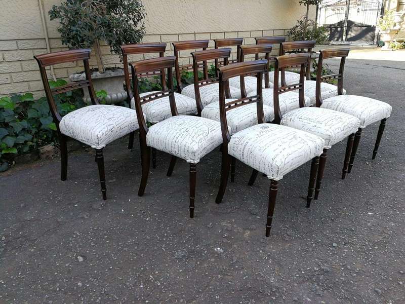 A Set of Twelve Regency Mahogany Dining Chairs upholstered in an exclusive and custom-made hand p...