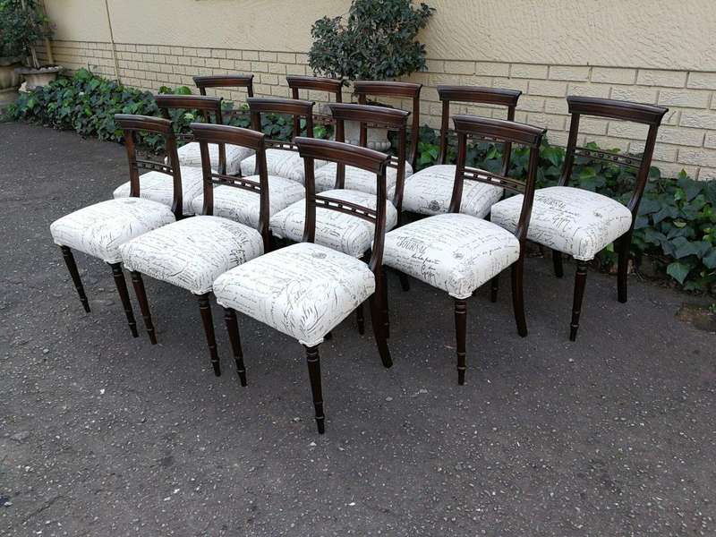 A Set of Twelve Regency Mahogany Dining Chairs upholstered in an exclusive and custom-made hand p...