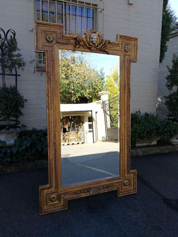 A Large Ornately Carved and Gilt Wood Bevelled Mirror