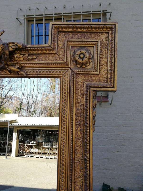 A Large Ornately Carved and Gilt Wood Bevelled Mirror