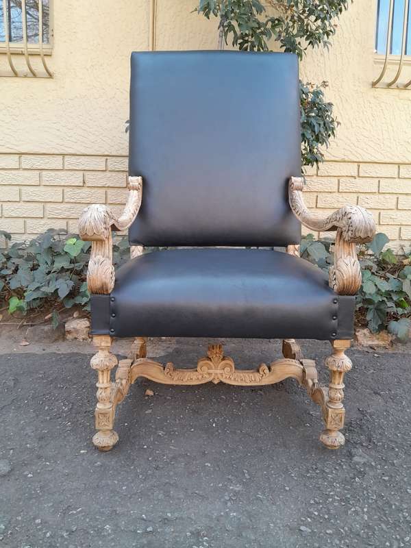 An Antique Ornately Carved Oak Throne Armchair Upholstered in Leather and in a Contemporary Bleac...