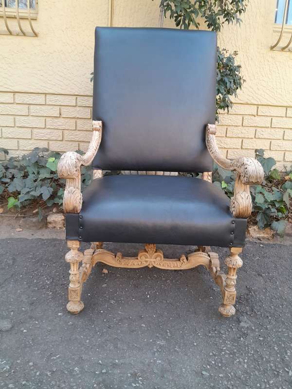 An Antique Ornately Carved Oak Throne Armchair Upholstered in Leather and in a Contemporary Bleac...
