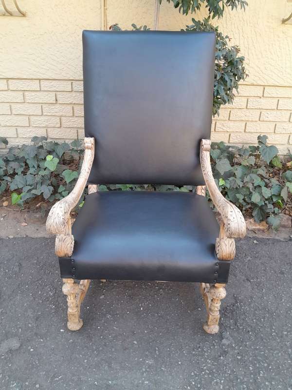 An Antique Ornately Carved Oak Throne Armchair Upholstered in Leather and in a Contemporary Bleac...