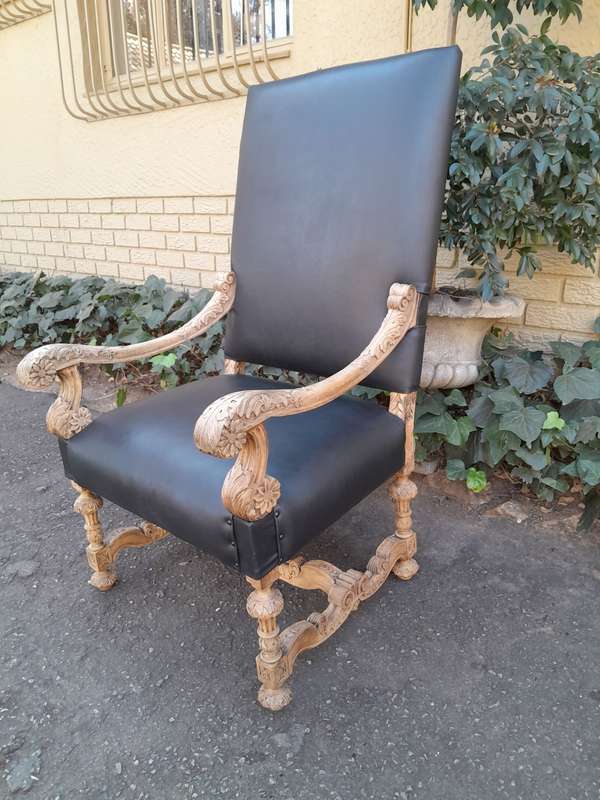 An Antique Ornately Carved Oak Throne Armchair Upholstered in Leather and in a Contemporary Bleac...