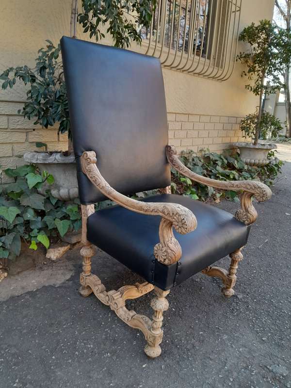 An Antique Ornately Carved Oak Throne Armchair Upholstered in Leather and in a Contemporary Bleac...