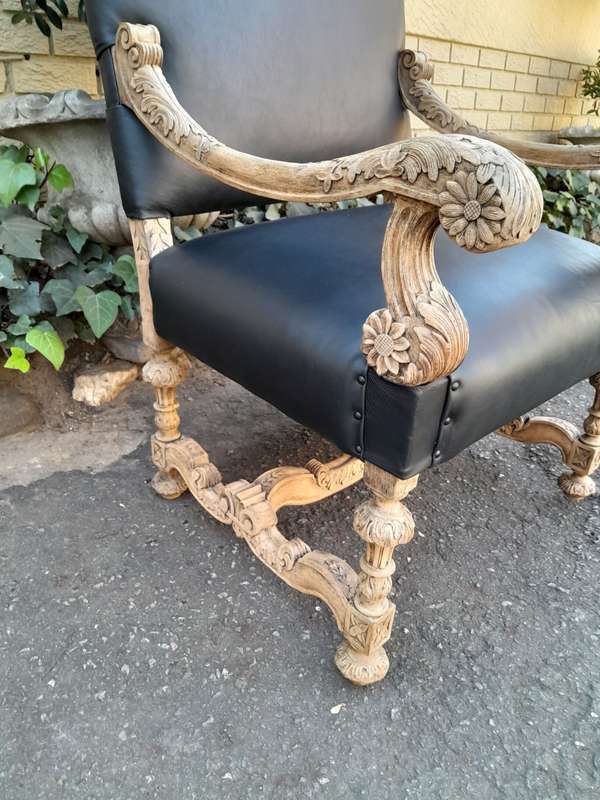 An Antique Ornately Carved Oak Throne Armchair Upholstered in Leather and in a Contemporary Bleac...