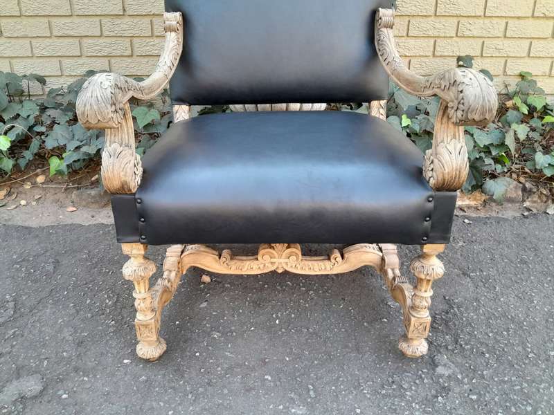 An Antique Ornately Carved Oak Throne Armchair Upholstered in Leather and in a Contemporary Bleac...