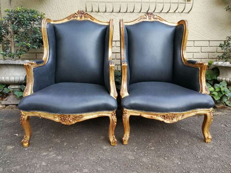A 20th Century Pair Of French Style Carved And Gilded Armchairs in Leather