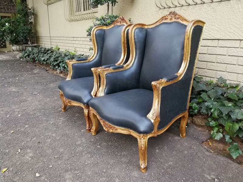 A 20th Century Pair Of French Style Carved And Gilded Armchairs in Leather