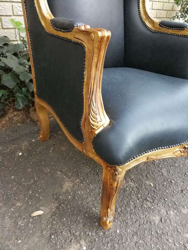A 20th Century Pair Of French Style Carved And Gilded Armchairs in Leather