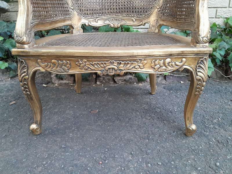 A 20th Century Pair or French Bergere Style Carved and Hand Gilded in Gold Leaf Wooden Chairs
