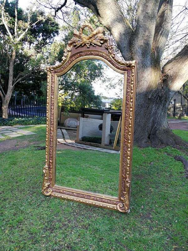 A French Rococo Style Ornately Carved and Gilded Bevelled Mirror