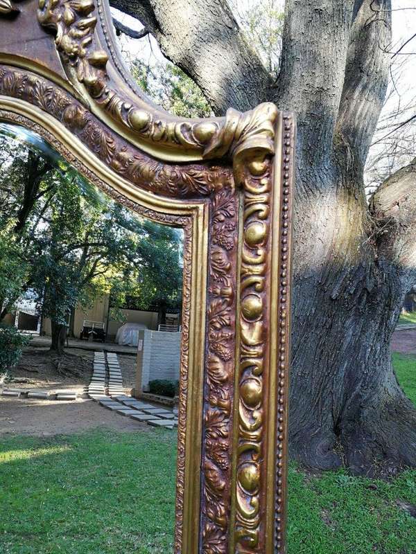 A French Rococo Style Ornately Carved and Gilded Bevelled Mirror