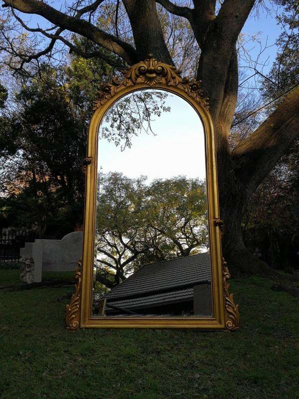 A French Style Ornately Carved Arched and Gilded Bevelled Mirror