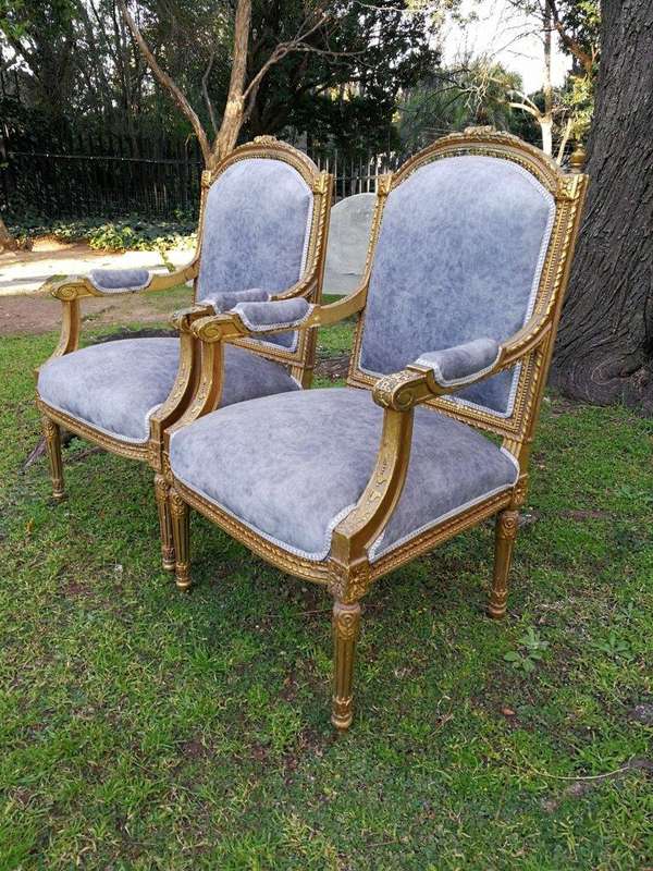 A Pair of French Style Giltwood Ornate Arm Chairs on Fluted legs 