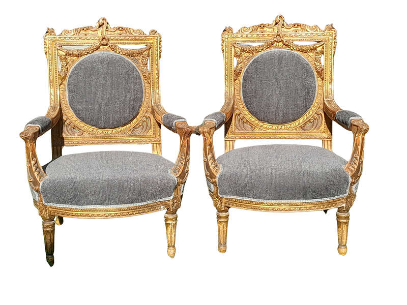 A 20th Century French Style Ornately Carved and Gilded Pair of Arm Chairs