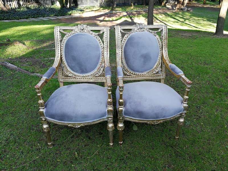 A 20th Century French Style Ornately Carved and Gilded Pair of Arm Chairs