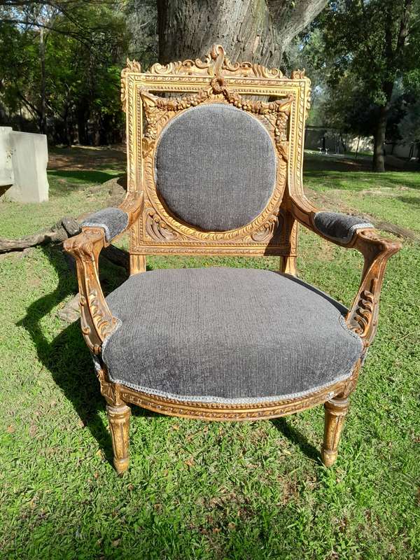 A 20th Century French Style Ornately Carved and Gilded Pair of Arm Chairs