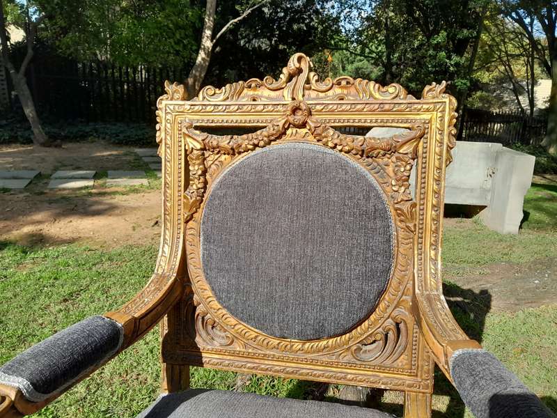 A 20th Century French Style Ornately Carved and Gilded Pair of Arm Chairs