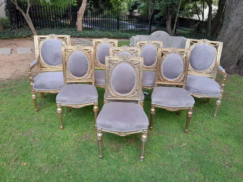 A Set of Eight French Style Ornately Carved and Gilded Dining Chairs (6 chairs and 2 Carvers)
