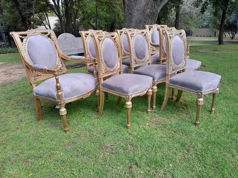 A Set of Eight French Style Ornately Carved and Gilded Dining Chairs (6 chairs and 2 Carvers)